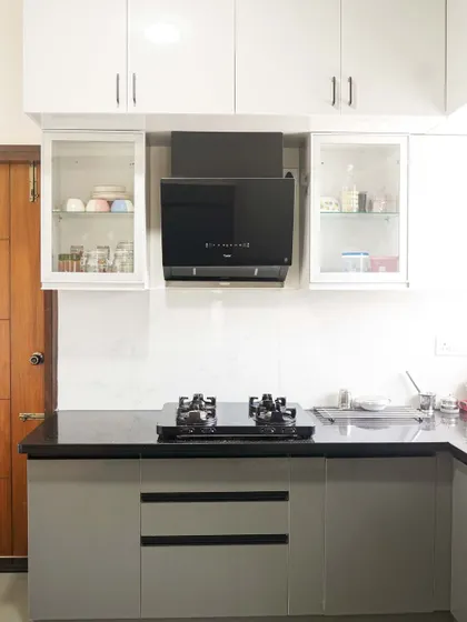 This perspective shows the clean lines and balanced proportions of the grey and white kitchen. The layout provides ample counter space, while the white marble-effect backsplash keeps the area feeling bright and spacious.