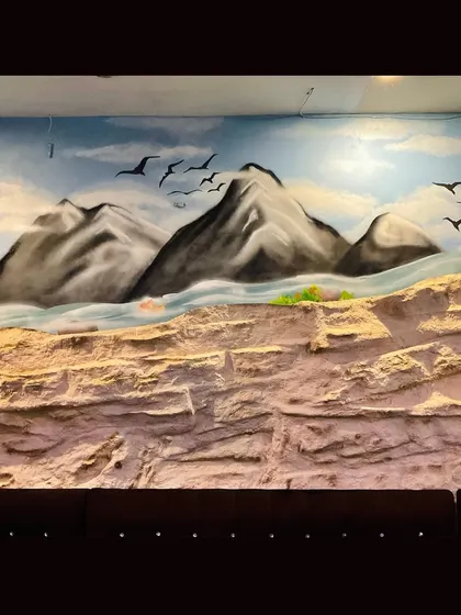 This part of the mural focuses on the mountain range, painted with spray cans to create soft gradients and a sense of distance. The flying birds add life and movement to the scene.