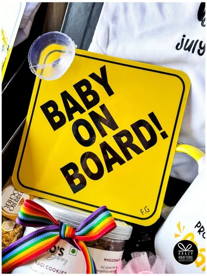 Another angle of our rainbow-themed announcement hamper, showing the 'Baby on Board' sign and custom onesie.