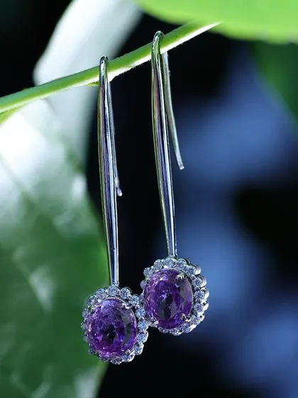 A simple green stem acts as a natural display for these drop earrings, creating a fresh and delicate look that emphasizes the product's elegant design.