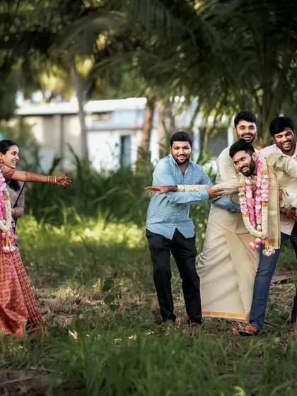 Weddings are about fun and family. We captured this playful 'tug-of-war' between the bridesmaids and groomsmen, a candid moment that shows the joy and friendly banter of the wedding day in Palladam.