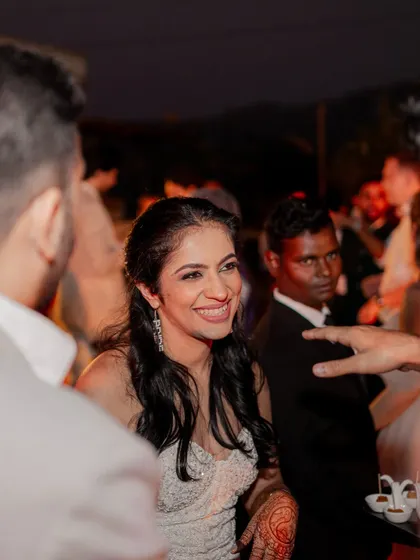 A candid shot of the bride smiling and interacting with guests at the reception. Her natural joy and the lively atmosphere of the party are beautifully captured.