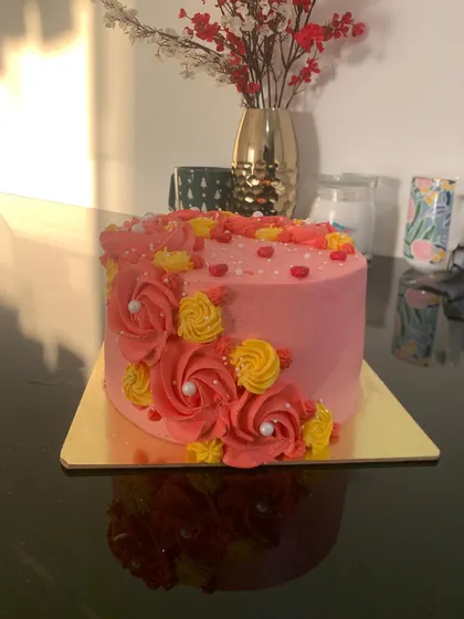 A pretty pink cake with pink and yellow floral piping. This is a simple, classic design that's always a beautiful choice.