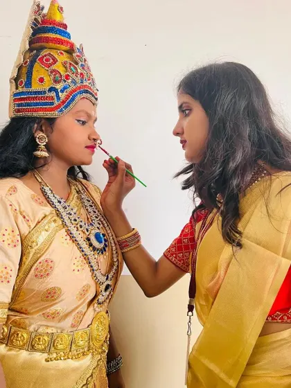 A behind the scenes moment, applying final touches to a performer's lips. This stage makeup is designed for durability and visibility during long dance or theatre shows.