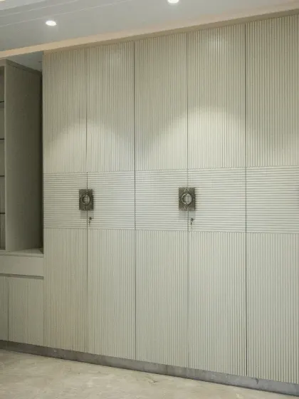 This elegant, floor-to-ceiling wardrobe integrates seamlessly into the room, featuring a built-in vanity with glass shelves for display.