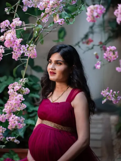 Surrounded by delicate pink blossoms, this mother-to-be glows with happiness. This is a perfect example of using natural elements to frame a beautiful maternity portrait.