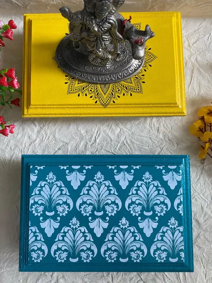 A top-down view of the yellow mandala chowki and the teal damask chowki. They are perfect for adding color to your pooja room.