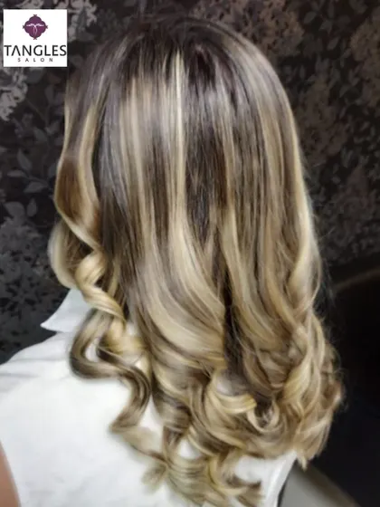 This is our hero item. A perfect example of a sun-kissed, golden blonde balayage. We achieved this look by hand-painting highlights to create a seamless, natural gradient, finished with soft curls to enhance the dimension and shine.