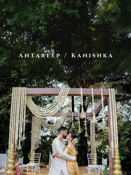 A romantic kiss under a beautiful, minimalist mandap. The image, with the couple's names overlaid, serves as a perfect title card for their wedding story.