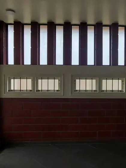 A room featuring a combination of low windows and high, louvered vents for excellent cross-ventilation.