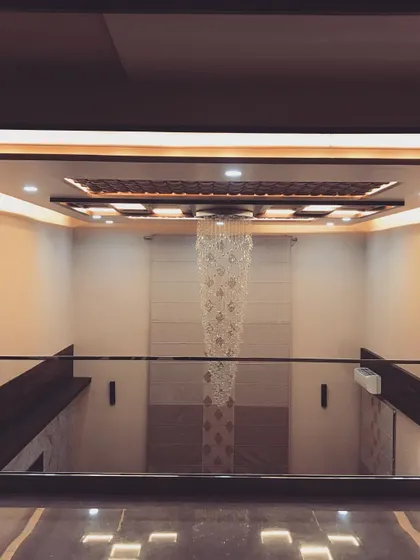 A duplicate of image 70, this view from the upper level emphasizes the symmetry and elegance of the double-height space and its luxurious lighting feature.