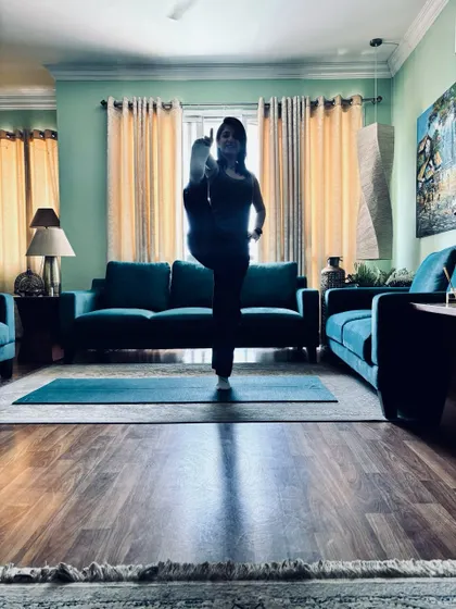 The same standing balance in colour, with the full living room around me.