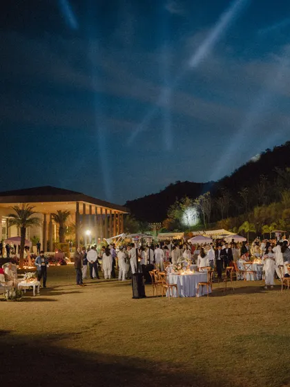 The magical atmosphere of Mouli and Jaymit's outdoor reception in Udaipur, with spotlights lighting up the night sky.