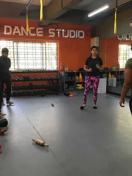 A master trainer demonstrates foot mobility exercises using simple tools like a tennis ball and a rolling pin.