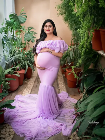 A full-length view of the gorgeous lavender gown in a garden setting. This shot highlights both the beauty of the mother and the elegance of the attire.