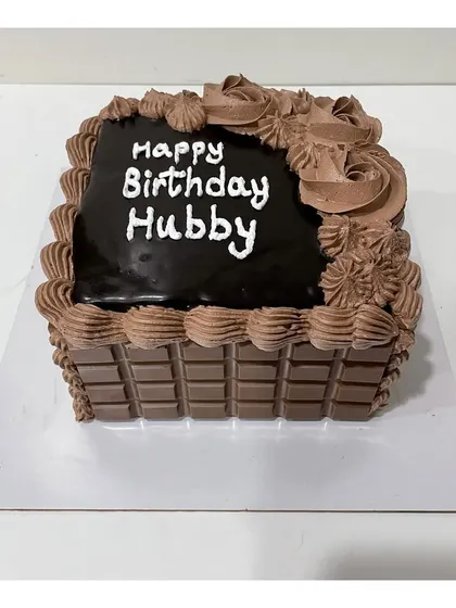 This chocolate cake design features a wall of Cadbury chocolate bars around the sides for an extra chocolatey experience.