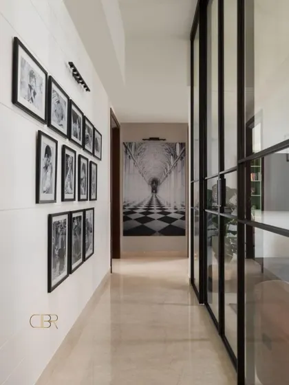 A hallway is more than just a passage; it's an opportunity to tell a story. In Casa Zen, I transformed this corridor into a personal gallery wall for family photos, complemented by a dramatic art piece and modern glass partitions that maintain an open feel.
