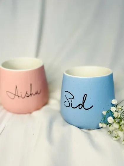 Matching pastel mugs, personalized for the happy couple. These are a popular item in our anniversary and wedding hampers.