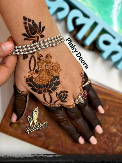 The joy of creating something beautiful and wearing it yourself. This is a design I did on my own hand, featuring a divine couple on a lotus, with the fingers dipped in dark henna.