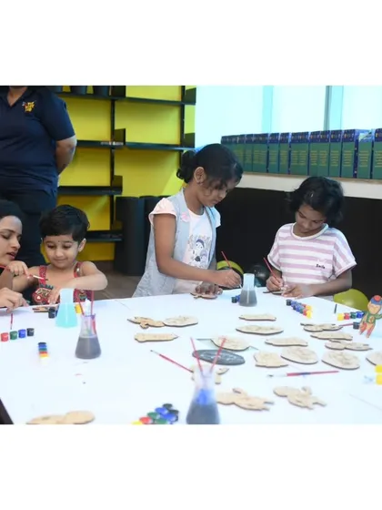 A mother and daughter paint together at our creative station. Our activities are designed to be enjoyable for the whole family, providing a great bonding experience.