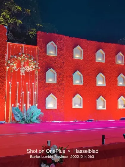 Adorn your wedding stage with the auspicious color red. This grand backdrop with its jharokha-style windows and warm lighting creates a regal and traditional setting for your ceremony.