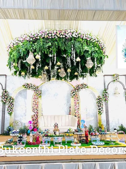 For this grand baby shower, I created a beautiful display in front of an elegant floral stage. The setup includes a variety of decorated platters on German silver stands, all coordinated to create a memorable welcome for the new baby.