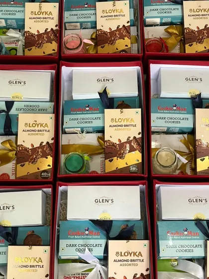 An inside look at our corporate gift boxes, filled with a selection of premium cookies from Cookie Man, almond brittle from Loyka, and scented candles.