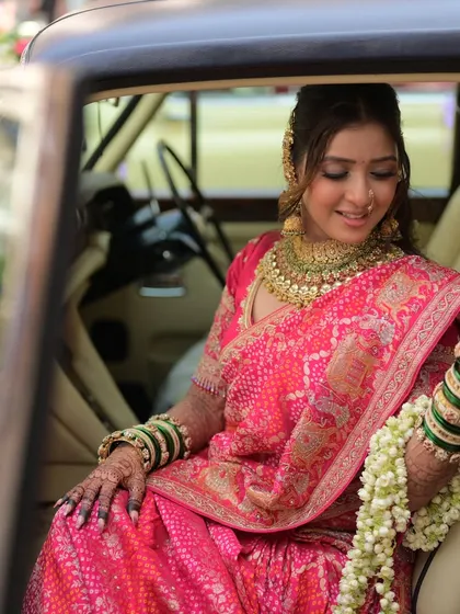 A moment of quiet elegance. The bride's soft glam makeup looks flawless as she sits in a vintage car, ready for her new beginning.
