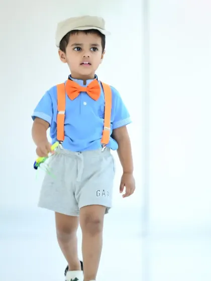 A full-body shot of the little boy in the Blippi-inspired outfit.