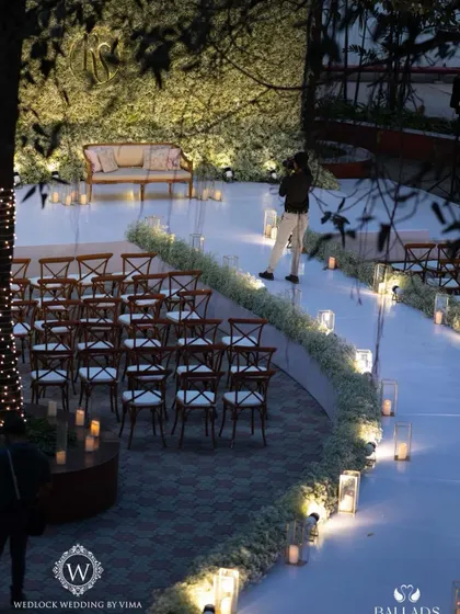 An ethereal all-white reception. The aisle and backdrop are adorned with clouds of baby's breath, while flickering candles cast a warm, romantic glow, creating a scene straight out of a fairy tale.