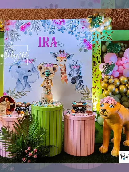 The main stage for Ira's jungle party, featuring a beautiful watercolor-style backdrop, themed dessert pedestals, and a life-sized lioness prop.
