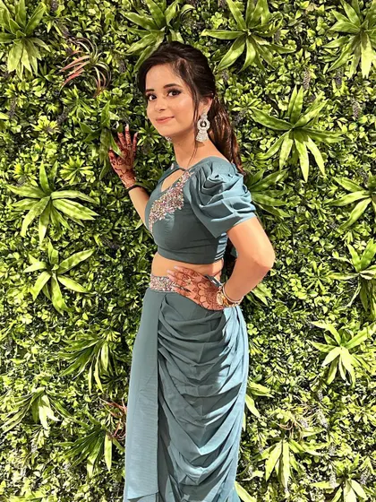 A client looking absolutely stunning in a custom-made teal draped dhoti-saree. The puff sleeves and embroidered blouse add a trendy and chic touch.
