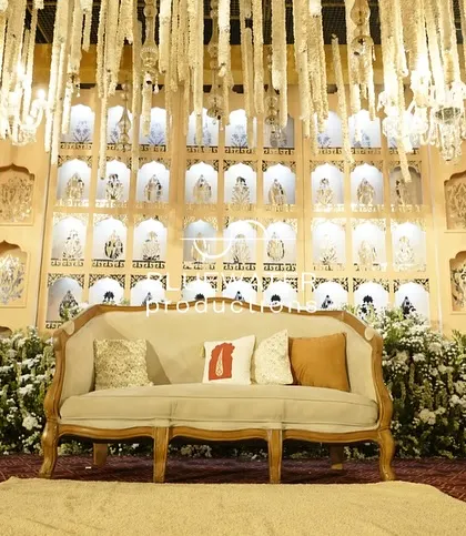 A comfortable lounge sofa set in front of the ornate reception stage, providing a perfect spot for photos.