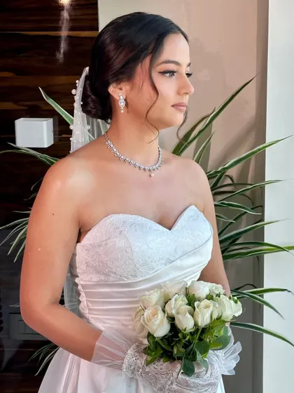 Beracah holding her bouquet of white roses. Her complete look, from the delicate veil to the soft makeup, is a perfect example of timeless Christian bridal beauty.