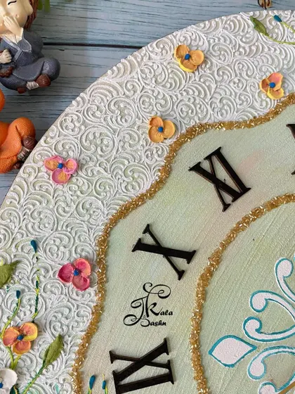 A detail shot of the white filigree border and tiny sculpted butterflies on the clock.