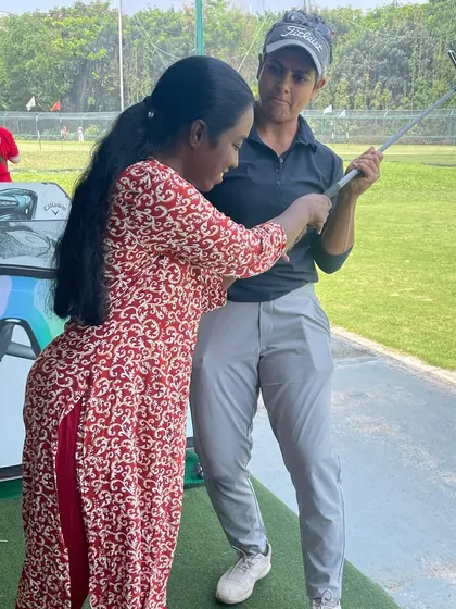 Working one-on-one with a student, I'm helping her feel the connection between her arms and body during the swing, a fundamental aspect of consistent ball striking.