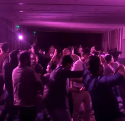 The party continues with purple lighting and a happy crowd.
