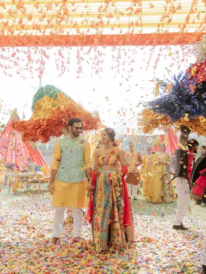 A wide-angle shot of the couple's grand entrance, showing the scale of the celebration and the vibrant decor.