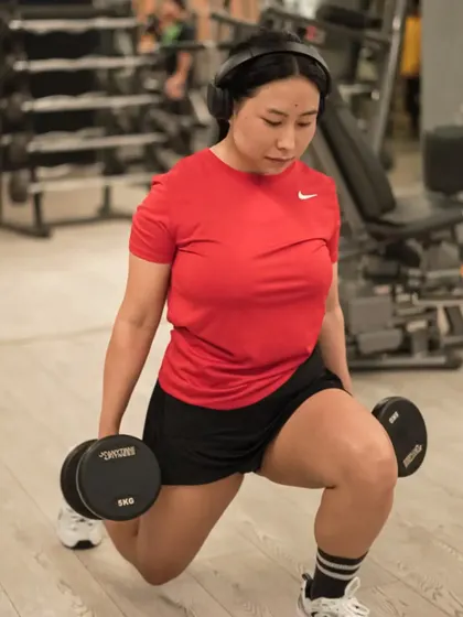 Dumbbell lunges are a fantastic exercise for toning and strengthening the entire lower body, as demonstrated by this client.