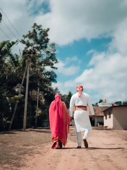 A wide shot of a couple walking hand-in-hand down a rustic path, symbolizing the start of their journey together.