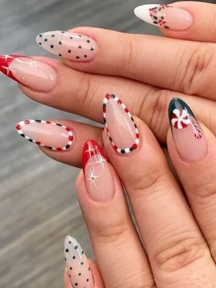 A chic and modern Christmas design on long, almond-shaped nails. This set features peppermint candy art, delicate polka dots, and sparkling star details, using a negative space technique for a trendy finish.