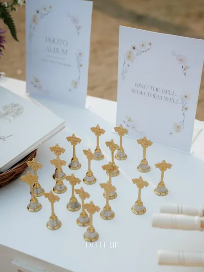 A 'Ring the Bell, Wish them Well' station, with small, elegant bells for guests to ring as the couple completes their vows. It's a beautiful, interactive way to involve guests in the ceremony.