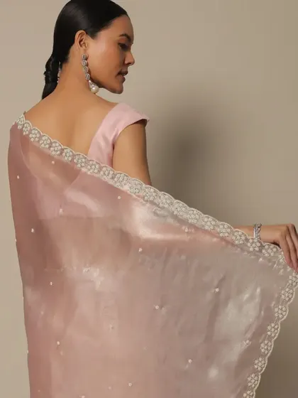 A view from the back, showing the simplicity of the low ponytail with the pink saree. This hairstyle is perfect for showcasing a designer blouse or back detail.