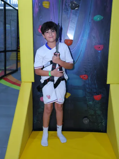 This young adventurer is all set with his safety harness to conquer the climbing wall.