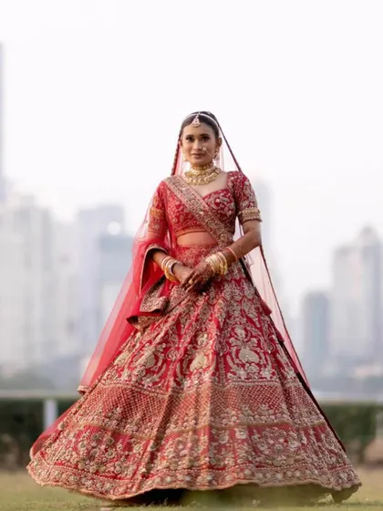 A grand bridal portrait with the Mumbai skyline as a backdrop. Her classic red lehenga and our signature subtle makeup create a powerful and unforgettable image.