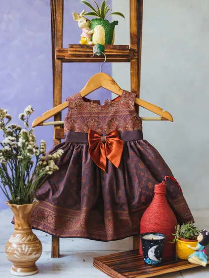 A beautiful brocade dress in rich, earthy tones, finished with a contrasting satin bow. A unique indo-western style.