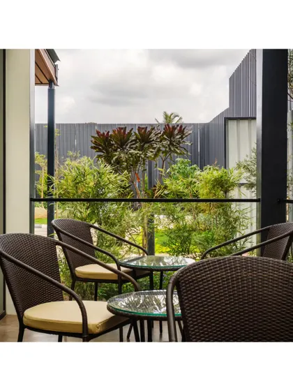 This outdoor seating area at the Prestige office provides a casual meeting spot or a place for a break, surrounded by lush greenery. We integrate these functional outdoor spaces to enhance the work environment.