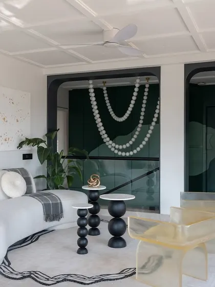 The lounge area on the upper floor of the Evelyn project is a space for unwinding. A sculptural white sofa, custom resin chairs, and abstract art create an environment that is both relaxing and visually stimulating.
