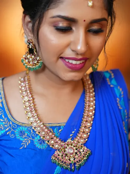 A close-up of a beautiful Jadau set, perfect for a Mehendi event or a semi-bridal look. The combination of pink and green stones against the royal blue saree is just stunning.