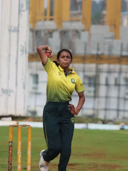 A female bowler follows through after delivering the ball, showing classic bowling form.